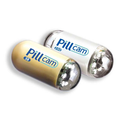 Two pill cam tablets sitting next to each other on a white background. The left pill is gold and the right pill is white, both have the words Pill Cam written on them.