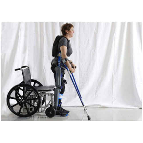 The profile of a woman with short hair standing up from her wheelchair and holding blue crutches.