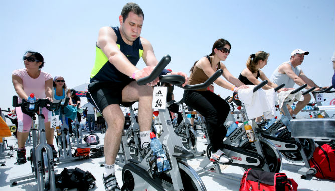 Four hours of physical activity like spinning a week will help employees avoid the effects of burnout and depression at work. Photo by Moshe Shai/Flash90.