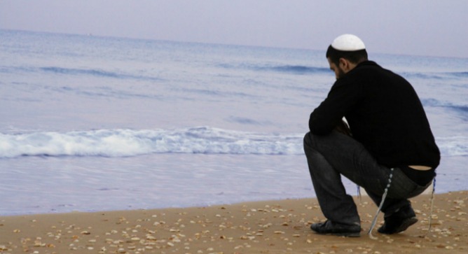 The hero, played by Roy Assaf, in a critically acclaimed scene where he begs divine help for his dilemma.