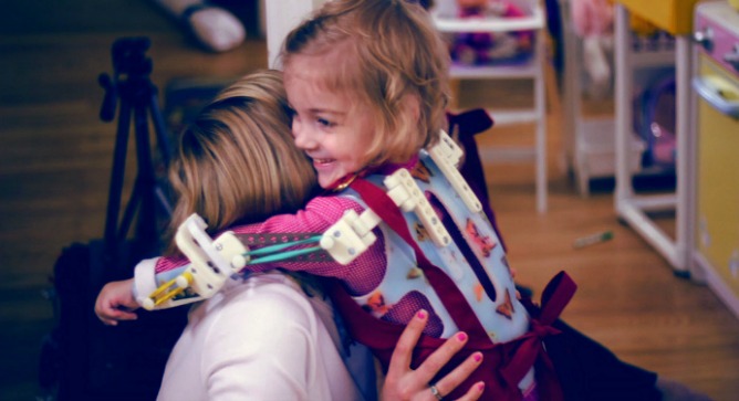 Emma using her Magic Arms printer-made exoskeleton.