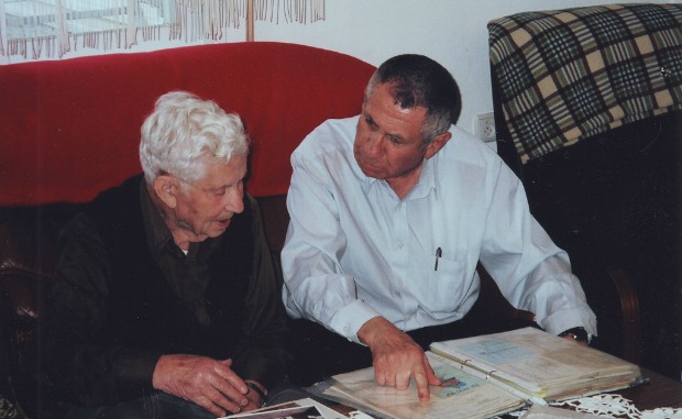 A Yad Sarah "Life Story" volunteer works with an elderly client to make a book for her family.