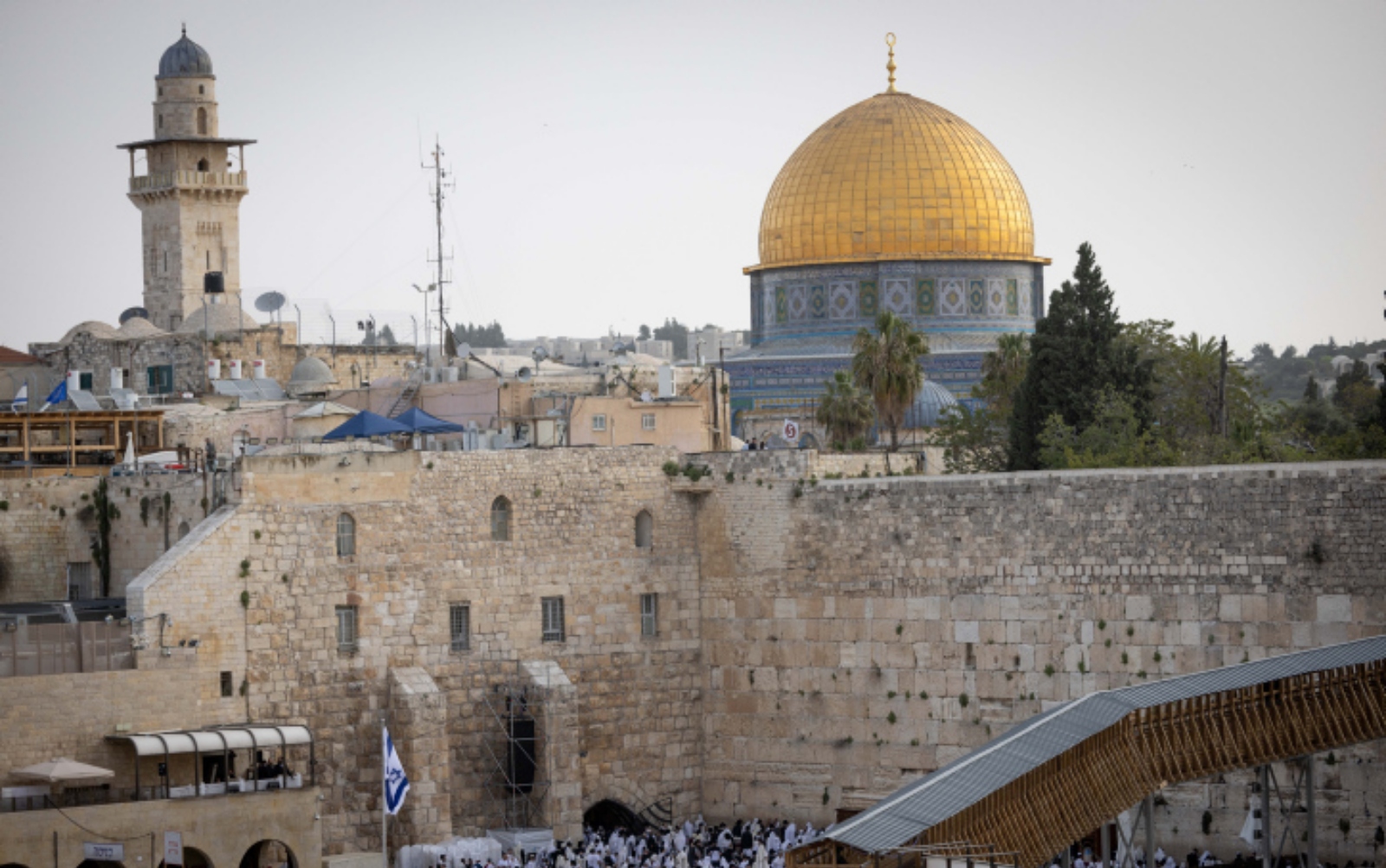 Jerusalem’s Old City is home to world-famous and monumental sites such as the Western Wall, the Temple Mount and the Church of the Holy Sepulchre. Photo by Yonatan Sindel/Flash90 View of Jerusalems Old City featuring the Western Wall in the foreground and the Dome of the Rock with its golden dome in the background. The area is bustling with people and is surrounded by historic architecture and trees.