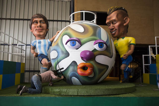 An Israeli worker works on figures depicting Argentine soccer player Lionel Messi and Brazilian player Neymar as part of the preparations for the Holon Adloyada parade on March 16. Photo by Yonatan Sindel/Flash90