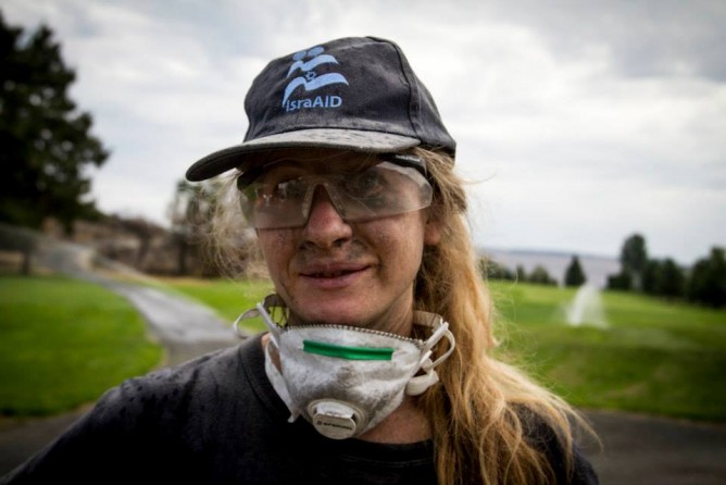 An IsraAID volunteer sifting through ashes in Washington State.