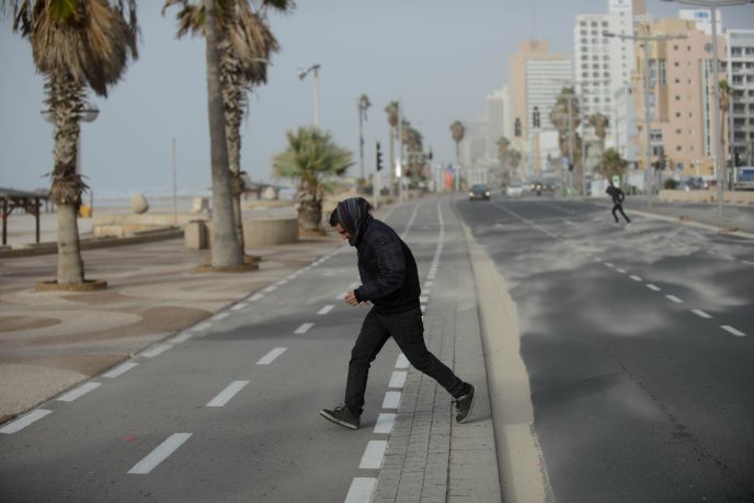 A man runs against sandy winds in Tel Aviv on January 6, 2014. Photo by Ben Kelmer/Flash90