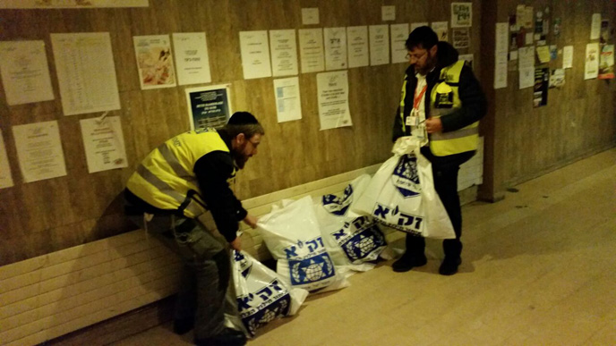 Collecting the blood-soaked findings in ZAKA bags for burial in accordance with Jewish law. (ZAKA)