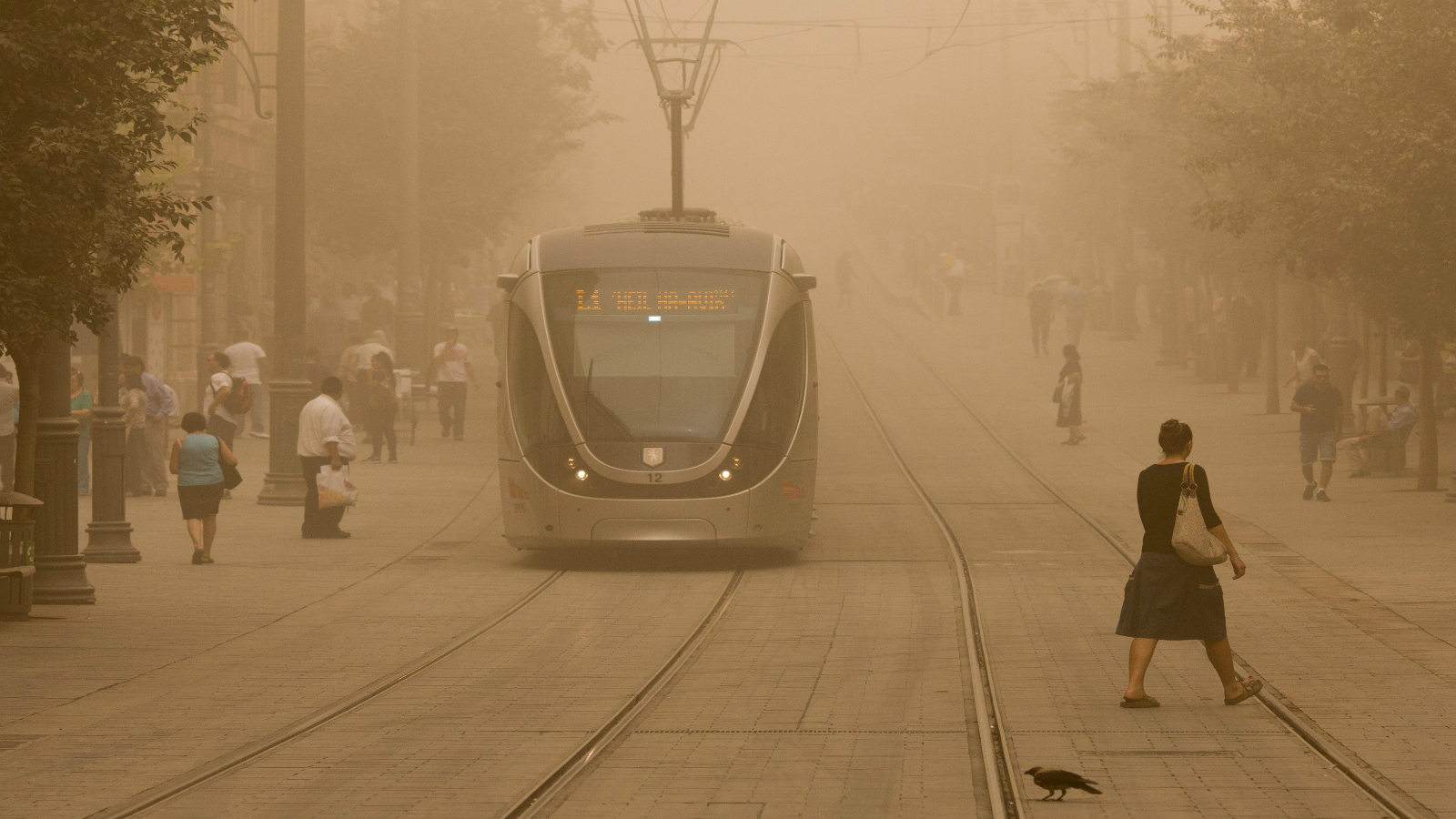 Israelis walk across the light-rail tracks on Jaffa Road in Jerusalem on September 8, 2015, as a sandstorm hit Israel. Photo by Yonatan Sindel/FLASH90
