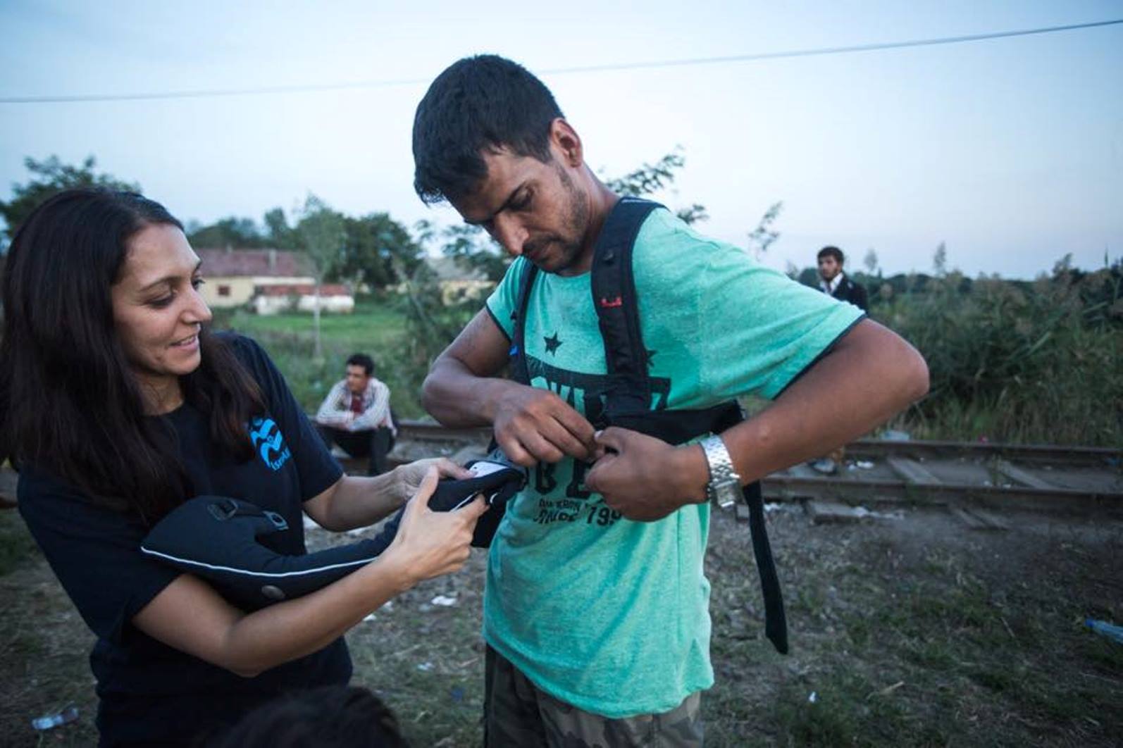 IsraAID volunteer Rachel Lasry Zahavi giving an Afghan refugee her Baby Bjorn sling. Photo by Mickey Noam Alon/IsraAID