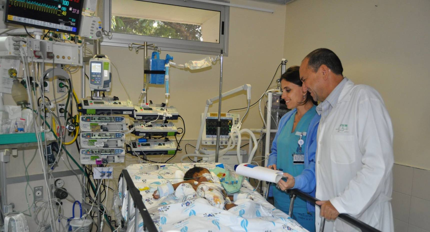 Dr. Sion Houri, head of the pediatric intensive care unit at Wolfson Medical Center, and head nurse Irena Nosel, tending to Dorice. Photo by Rachel Werner Dr. Sion Houri, head of the pediatric intensive care unit at Wolfson Medical Center, and head nurse Irena Nosel, tending to Dorice. Photo by Rachel Werner