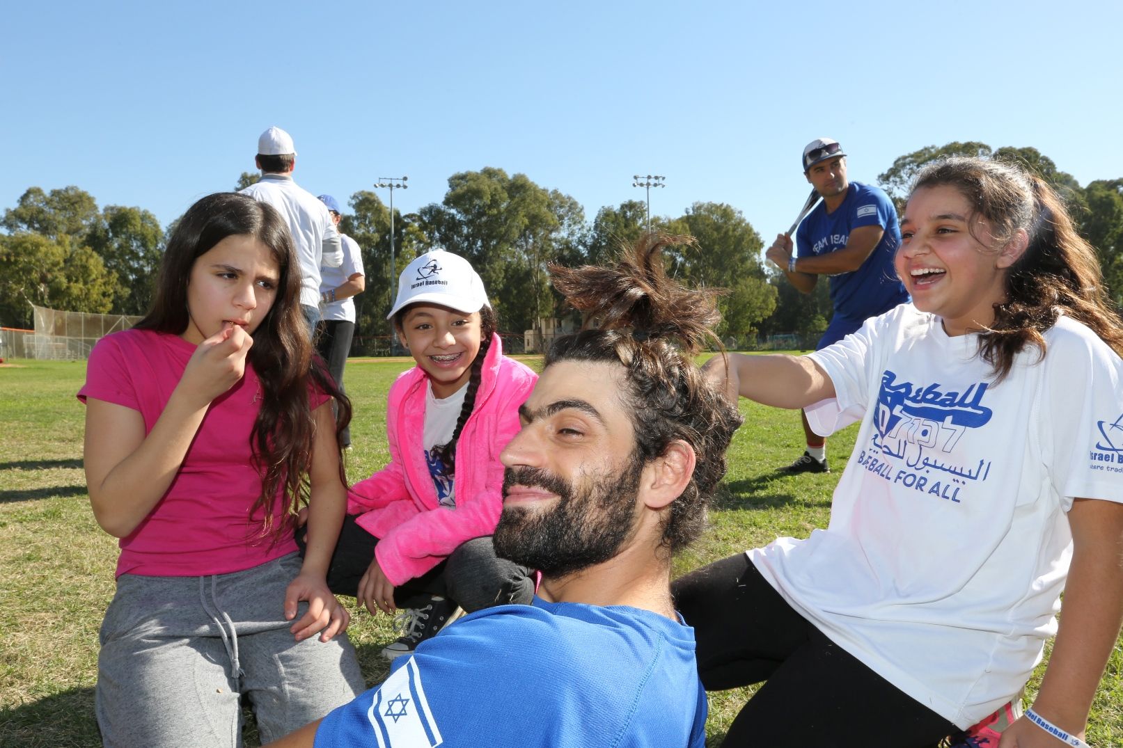 Participants from Ramle kidding around with head coach Ophir Katz. Baseball for All director Nate Fish is in background at right. Photo: Yossi Zamir/JNF Participants from Ramla kidding around with head coach Ophir Katz. Baseball for All director Nate Fish is in background at right. Photo: Yossi Zamir/JNF
