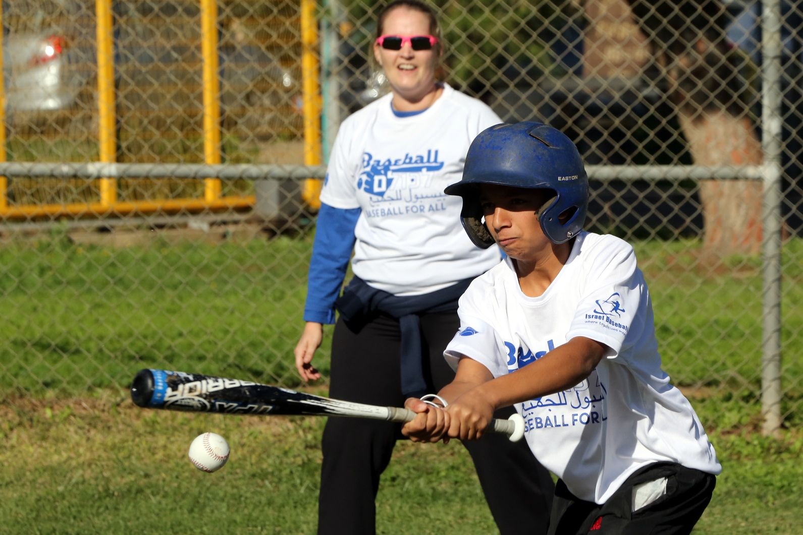 Girls’ turn at bat, with Baseball for All official Callie Caughron looking on. Photo by Yossi Zamir/JNF Girls’ turn at bat, with Baseball for All official Callie Caughron looking on. Photo by Yossi Zamir/JNF