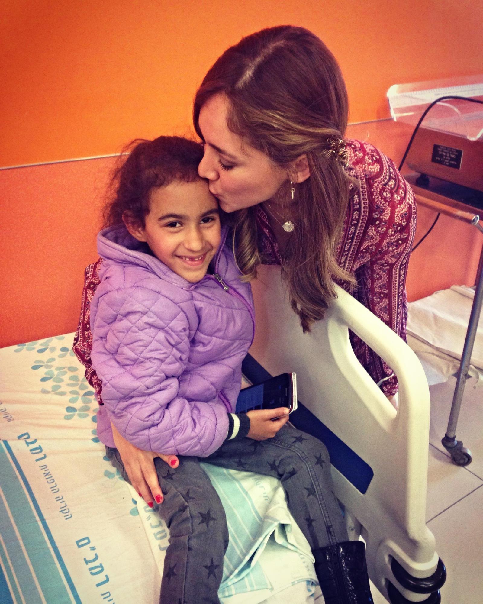 Telenovela actress Sherlyn Gonzalez comforting a young patient at Rambam Health Care Campus. Photo courtesy of America's Voices in Israel