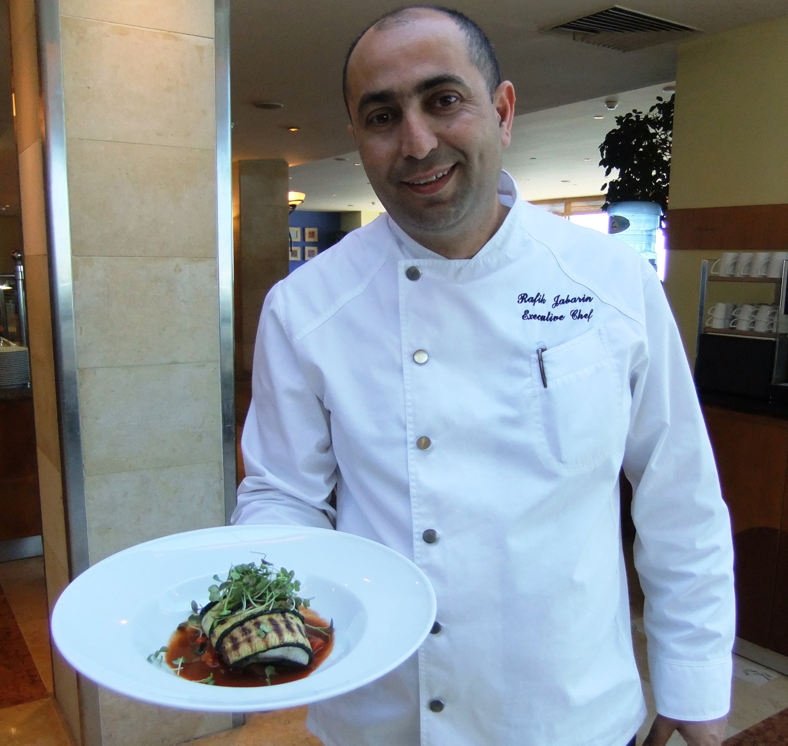  Rafik Jabarin, executive chef of the Tel Aviv Hilton, with his sea bass dish. Photo courtesy of Hilton Worldwide