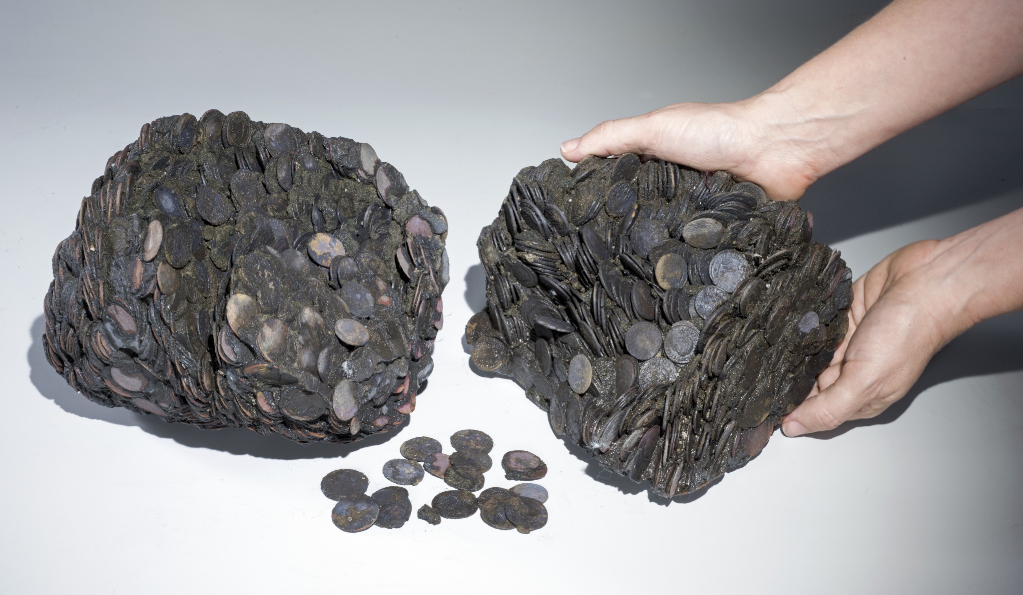 Lumps of coins that were discovered at sea, weighing a total of c. 20 kilograms. Photo by Clara Amit, courtesy of the Israel Antiquities Authority