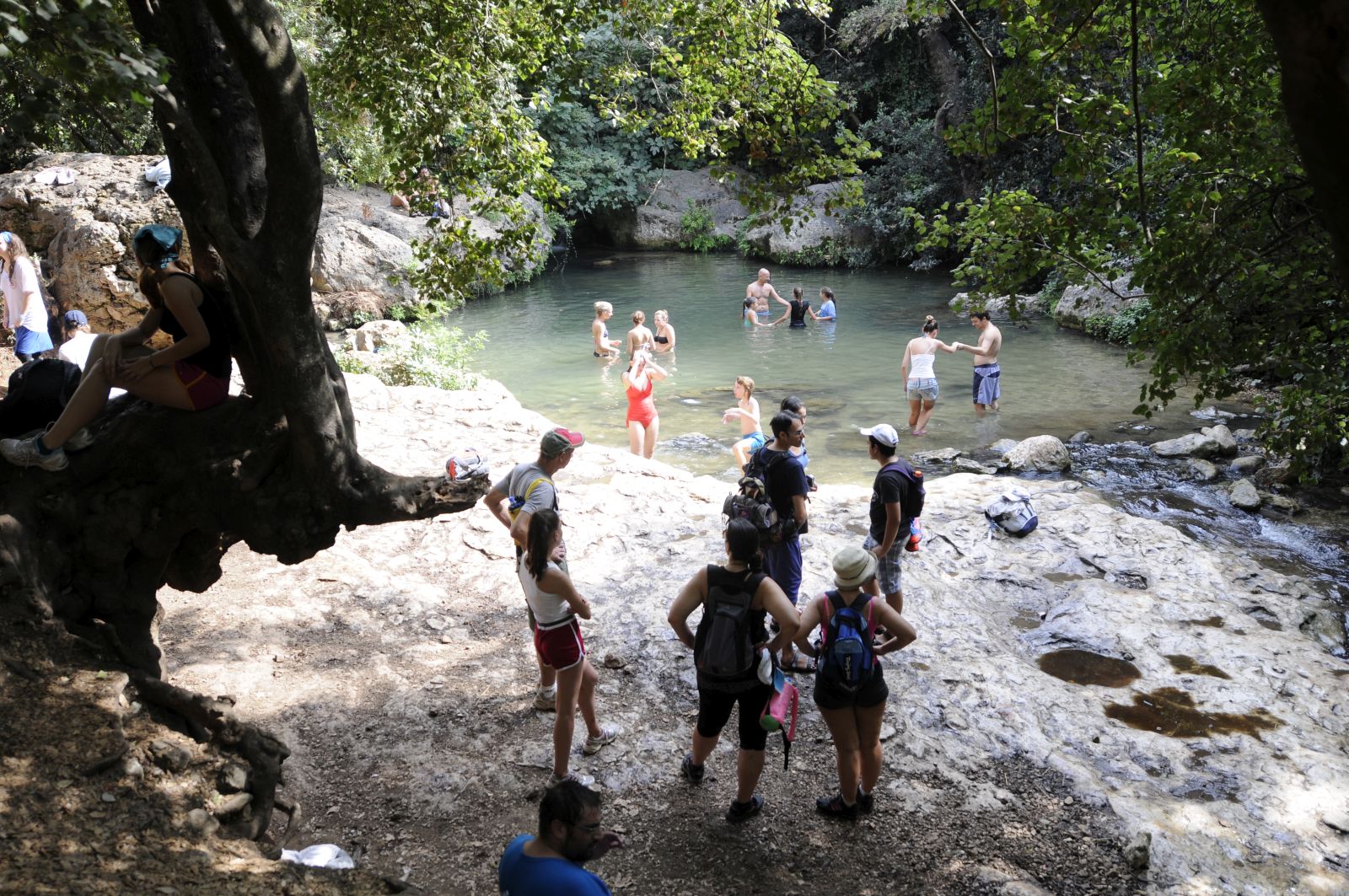 Hikers relax by a spring in the Golan Heights. Photo by Louis Fisher/FLASH90
