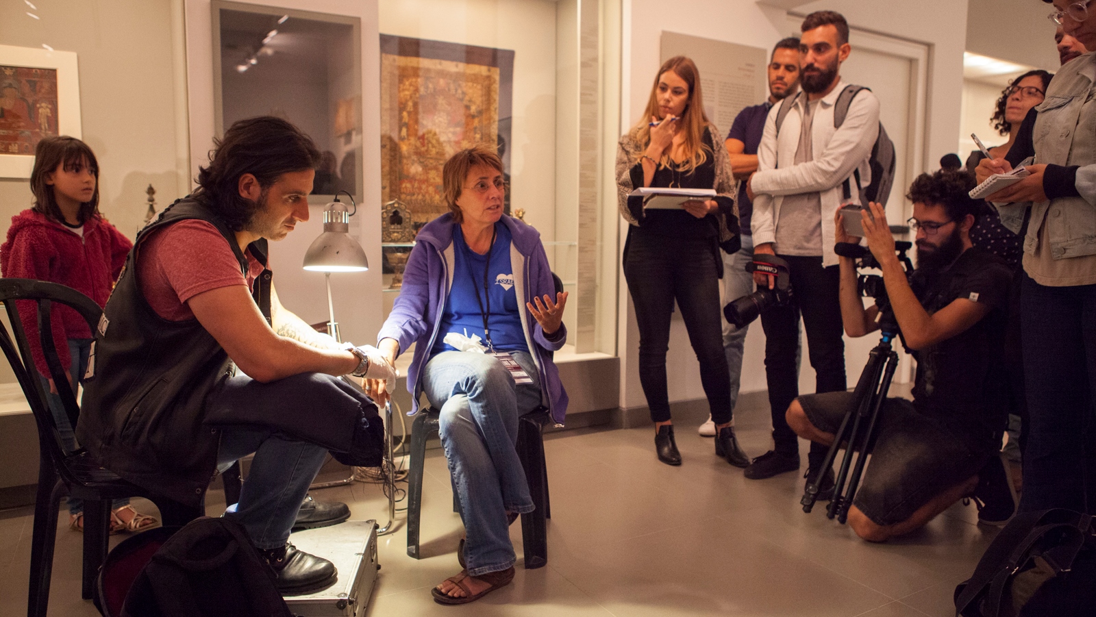 Wassim Razzouk tattoos terror victim Kay Wilson in the Asian Art Wing at the Israel Museum. Photo: courtesy