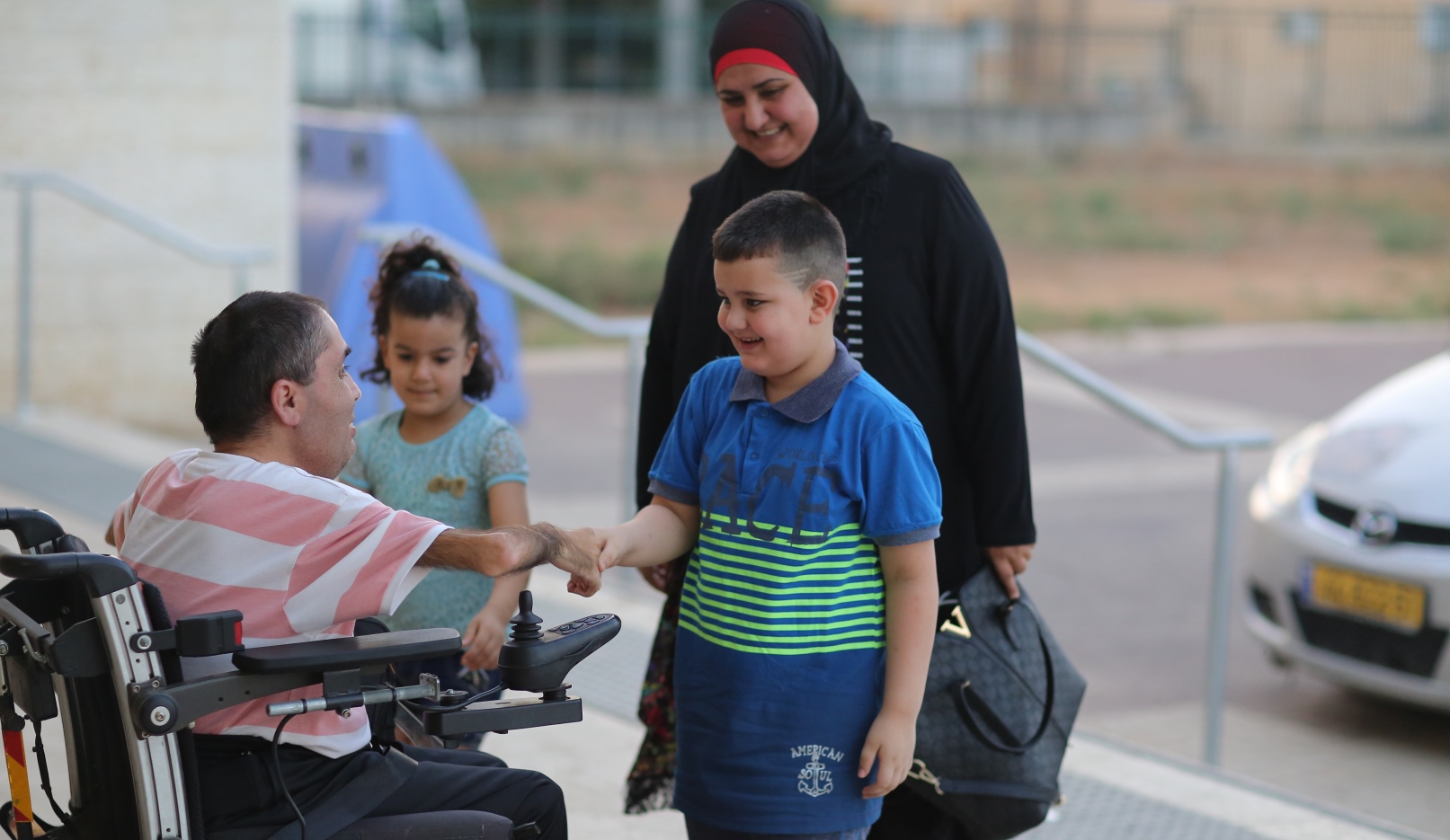 Children greeting Family Advancement Center director Nawaf Zmiro at the Sindian Center in Kalansua. Photo: courtesy