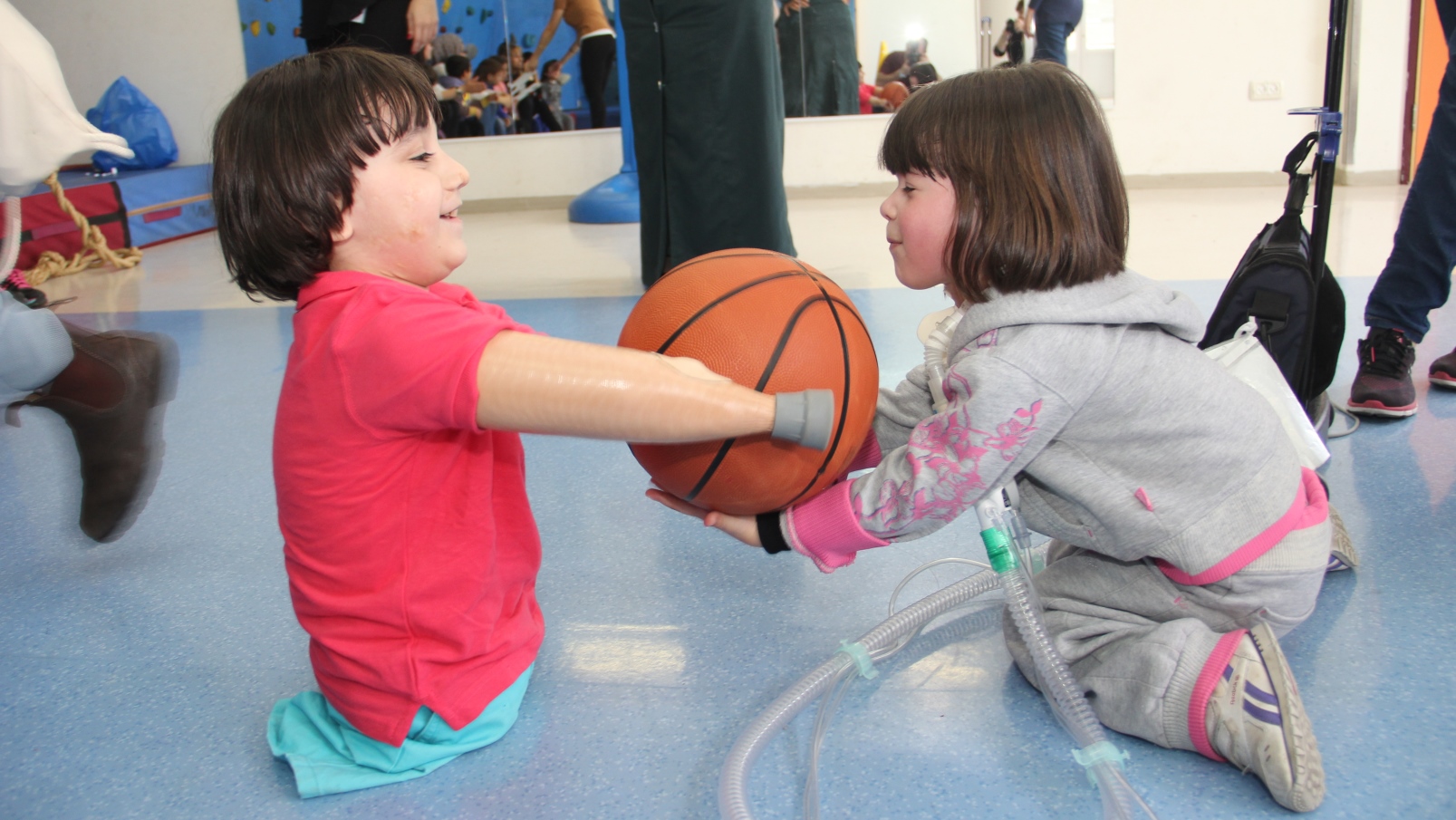A boy who lost his limbs to predatory bacteria playing with another child at ALYN with the help of assistive gear. Photo courtesy of ALYN