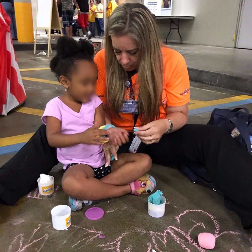 Psychotherapist Einat Kauffman in the Dallas Convention Center helping with a child draw a picture of her home. Photo courtesy of United Hatzalah