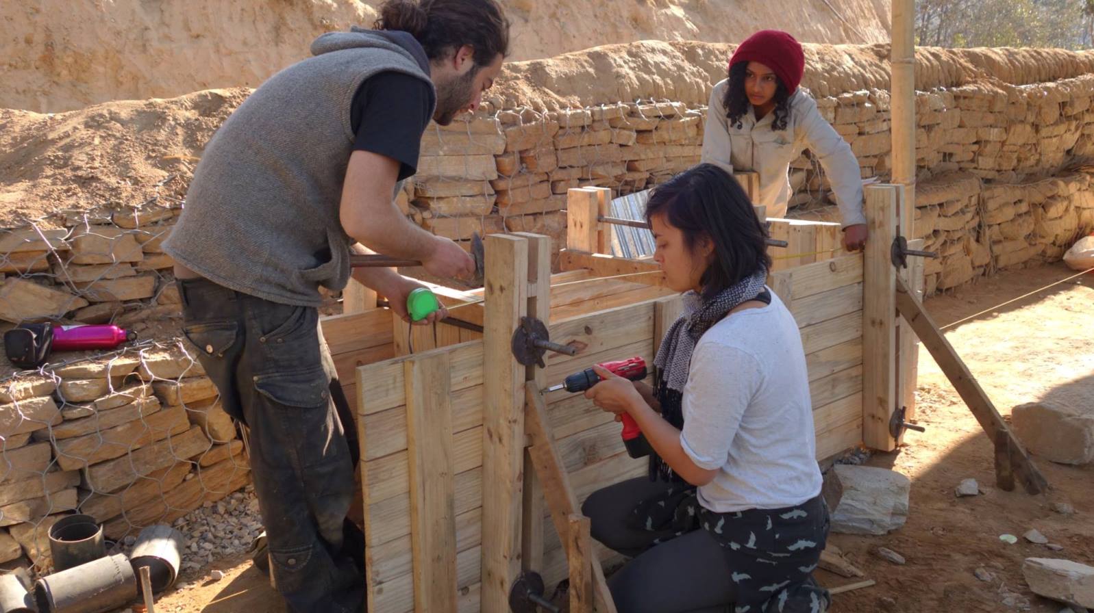 Nitzan Iserovitch of Back to Earth Community, left, teaching Nepali women to build a rammed-earth formwork. Photo via Facebook