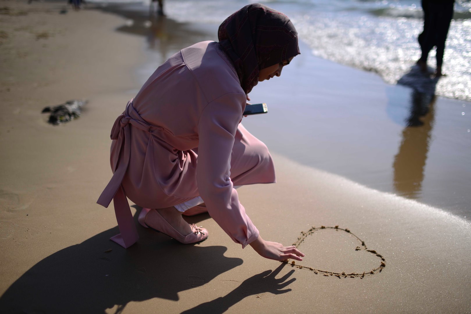 A woman makes her mark in the sand at Jaffa. Photo by Tomer Neuberg/FLASH90