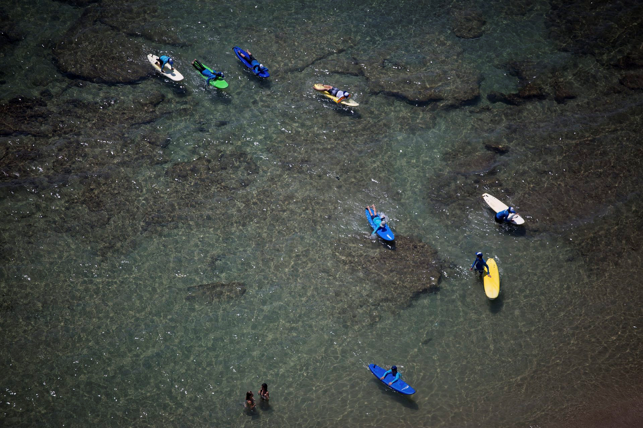 Teenagers take a breather during a surfing class on the beach in Tel Aviv. Photo by Miriam Alster/Flash90
