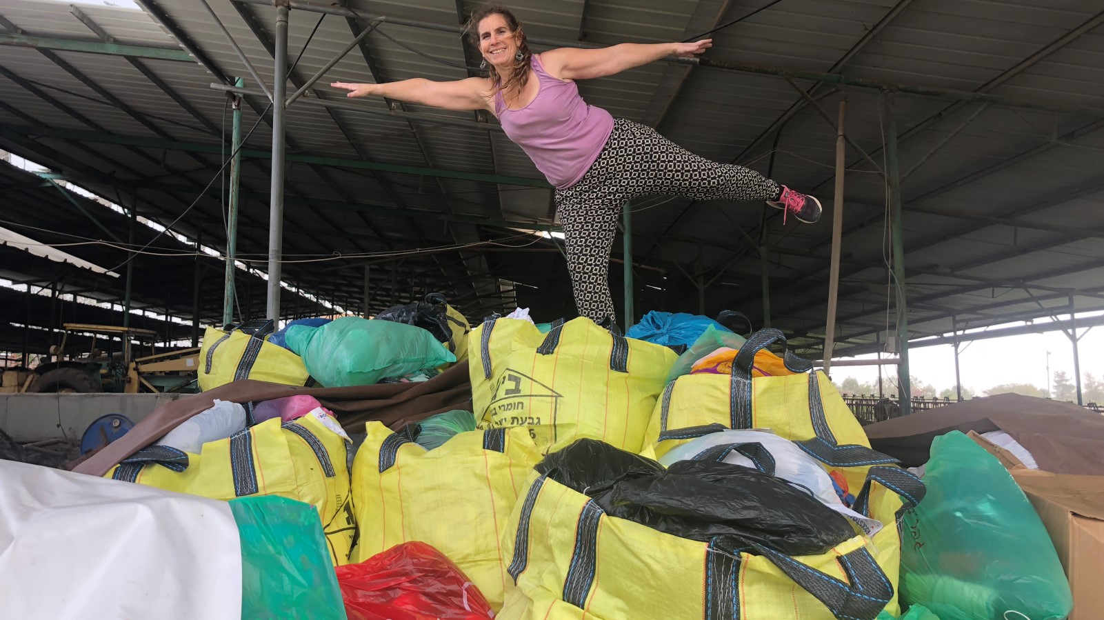 Golan resident and Friend Ships volunteer Gila Ron atop a mountain of clothing donations for displaced Syrians. Photo courtesy of Teri Shields