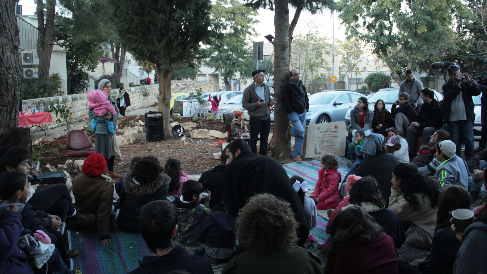 Guy Gardi, center, speaking at an event in the community garden built by members of Kibbutz Beit Yisrael for local residents. Photo: courtesy