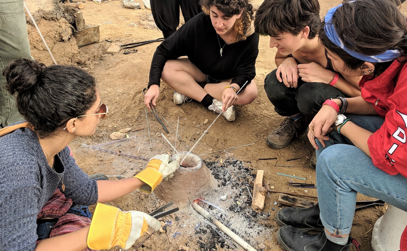 Industrial design students shape glass beads over an open fire at Bezalel Academy’s annual Dead Sea Seminar. Photo: courtesy