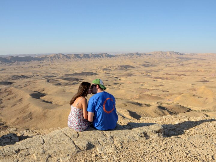 A couple sits by a lookout point of the Ramon Crater. Photo by Zoe Vayer/Flash90