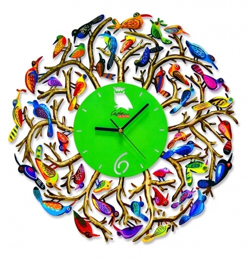 A vibrant wall clock with a green face and white hour markers. Surrounding it are colorful, stylized birds perched on golden branches, each bird painted in different bright colors, creating a lively, artistic design.