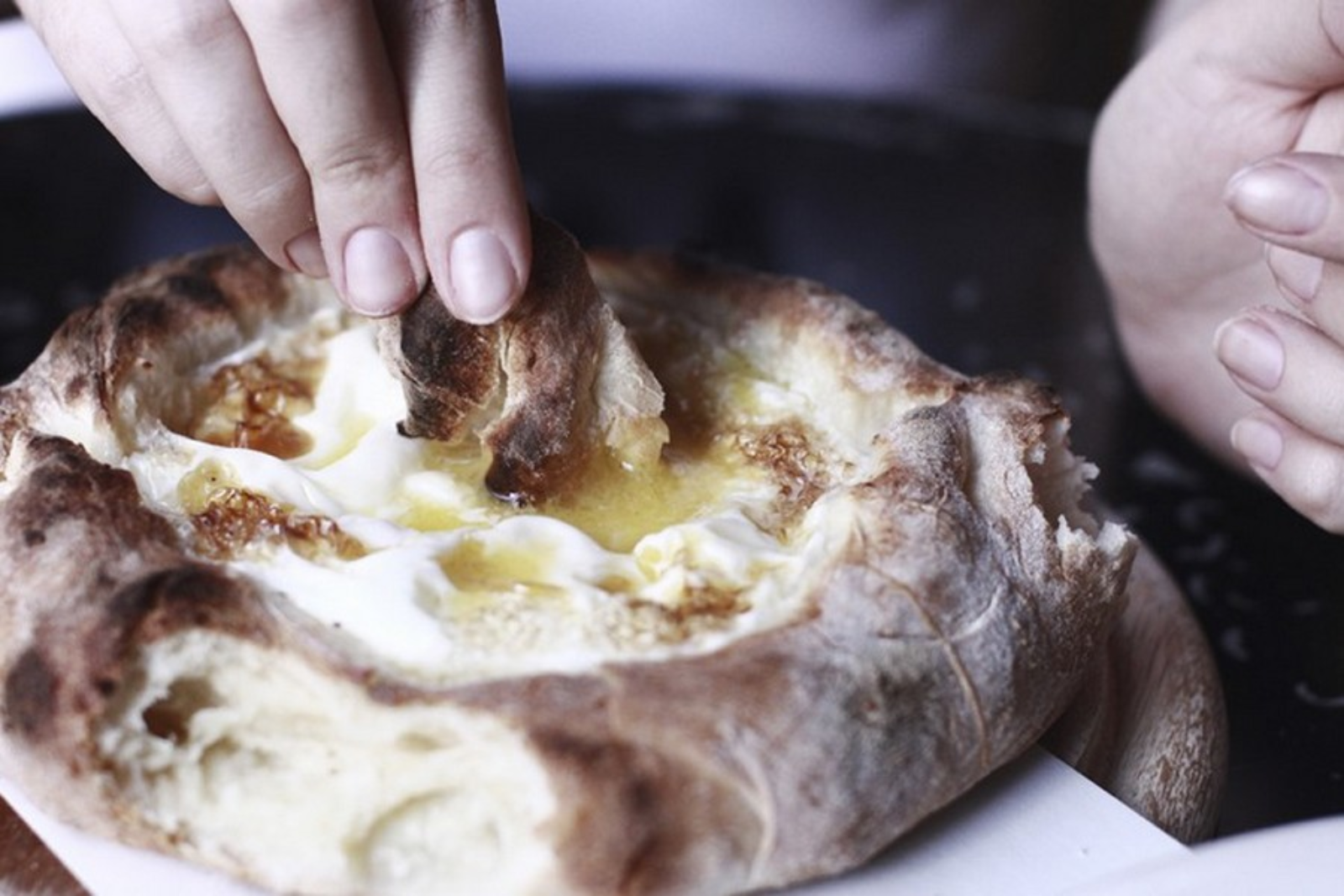 Khachapuri, a classic Georgian bread boat brimming with cheese, egg and butter. Photo courtesy of Hachapuria.