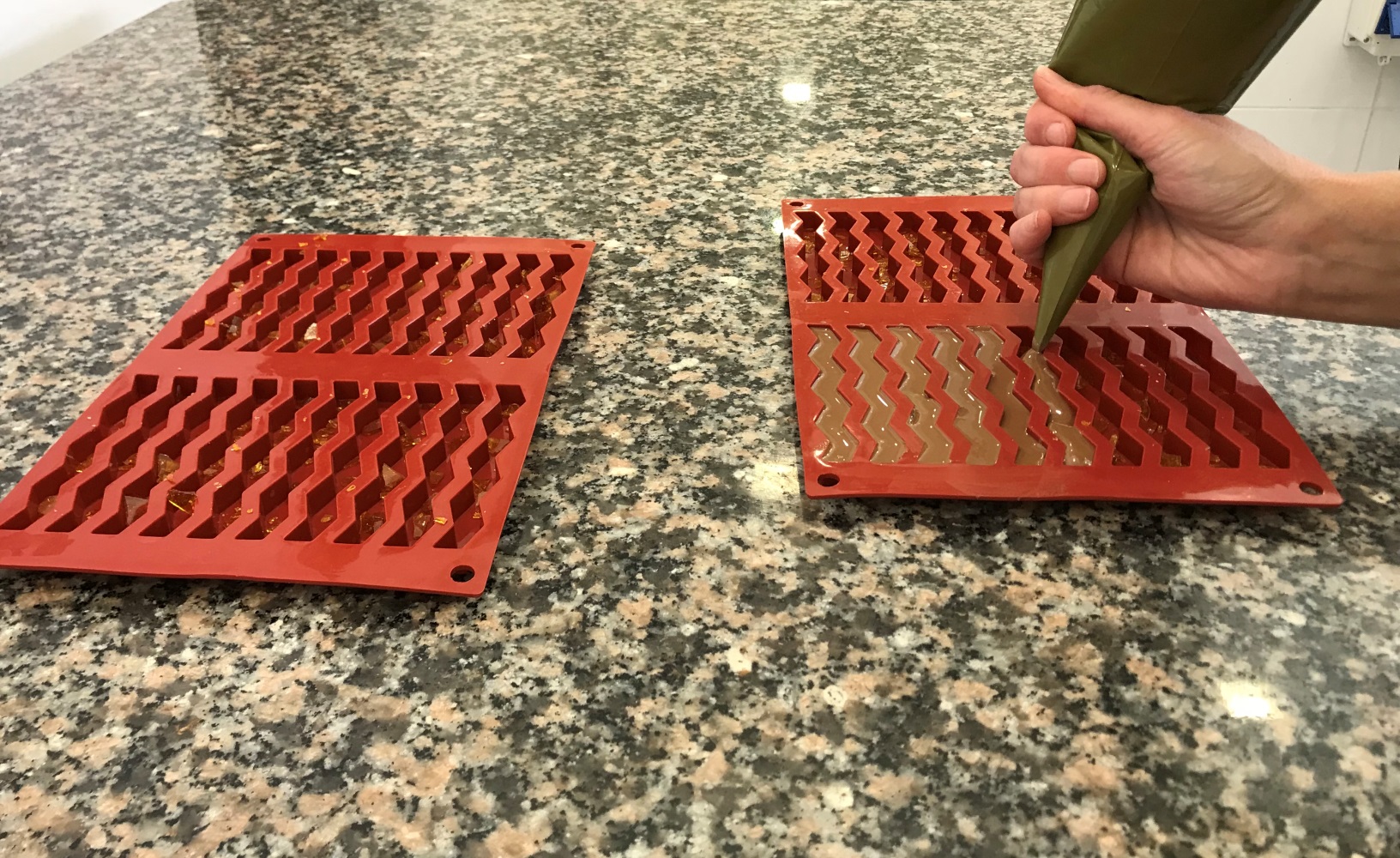 Piping warm, caramel-flavored chocolate into the molds at IKA Chocolate. Photo by Naama Barak