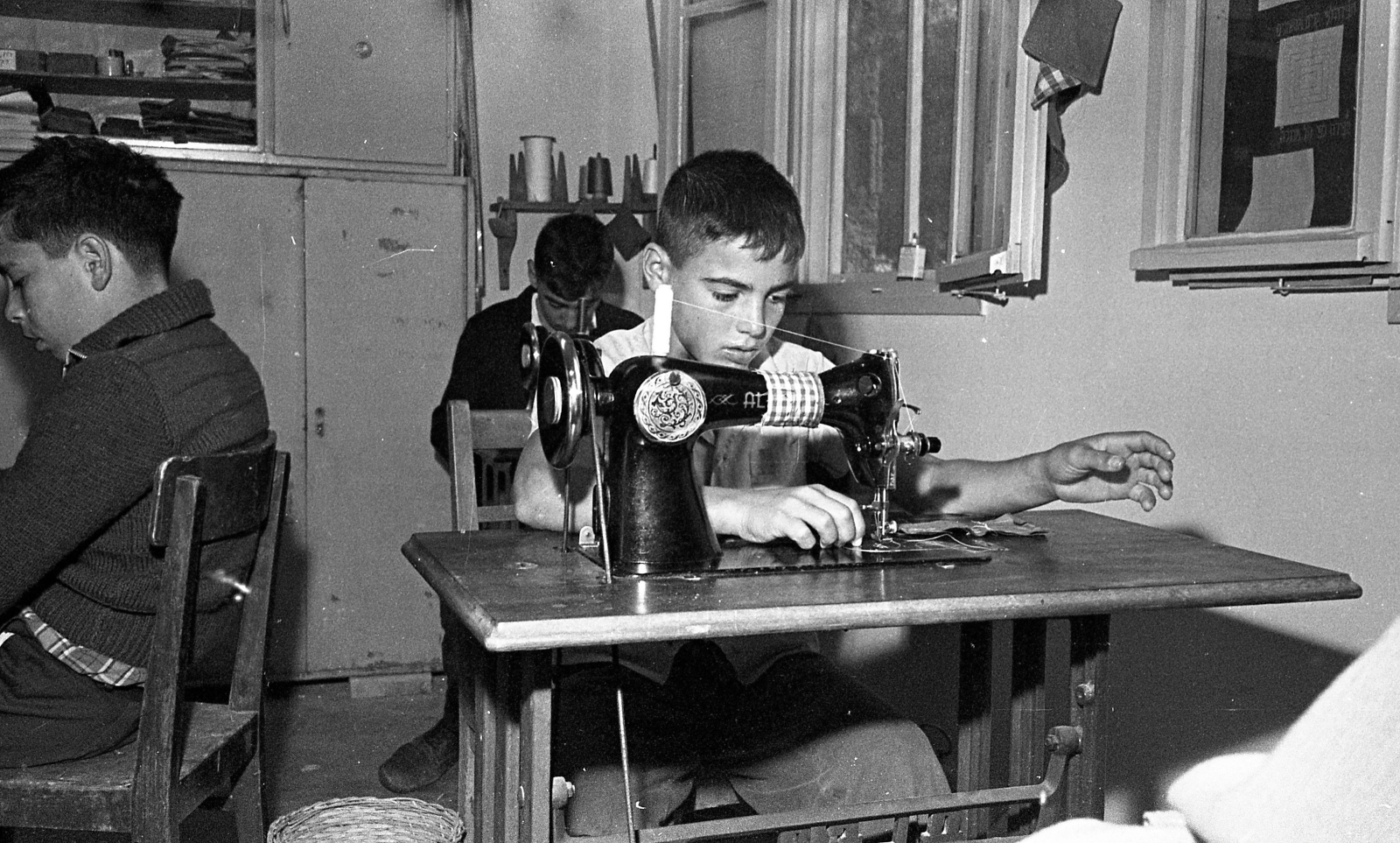 This boy learning to sew lived on Kibbutz Beit Alfa in 1961, but his name and history are unknown. Photo courtesy of the Dan Hadani Photo Archive/Pritzker Family National Photography Collection at the National Library of Israel