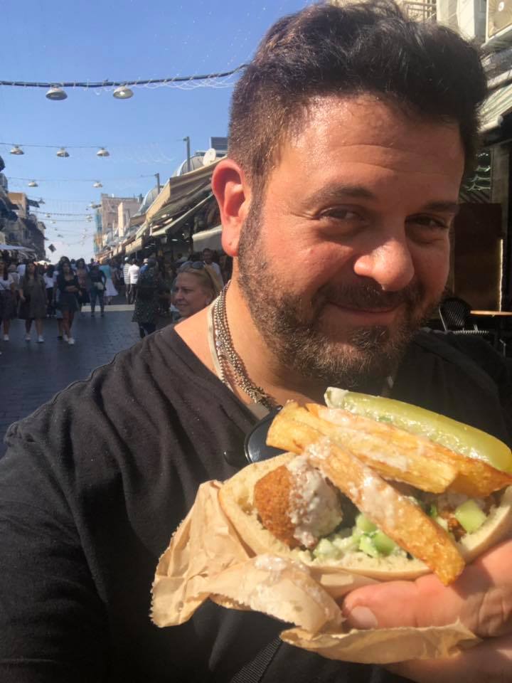 Adam Richman enjoying falafel in Machane Yehuda, complete with fries and pickles. Photo via Facebook