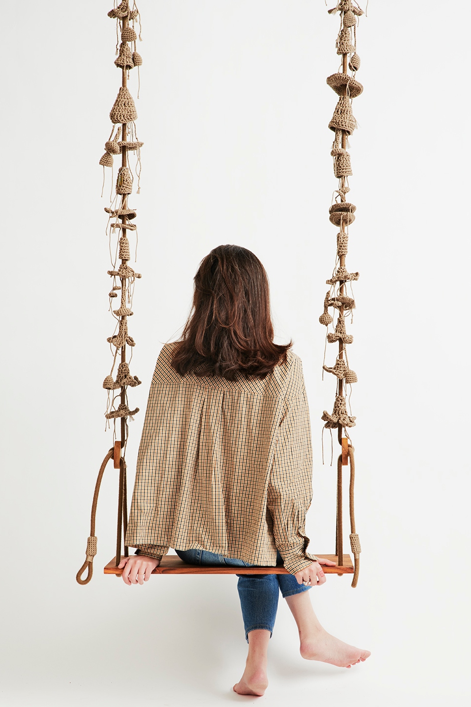 A crocheted and wooden swing by Iota. Photo by Noam Preisman