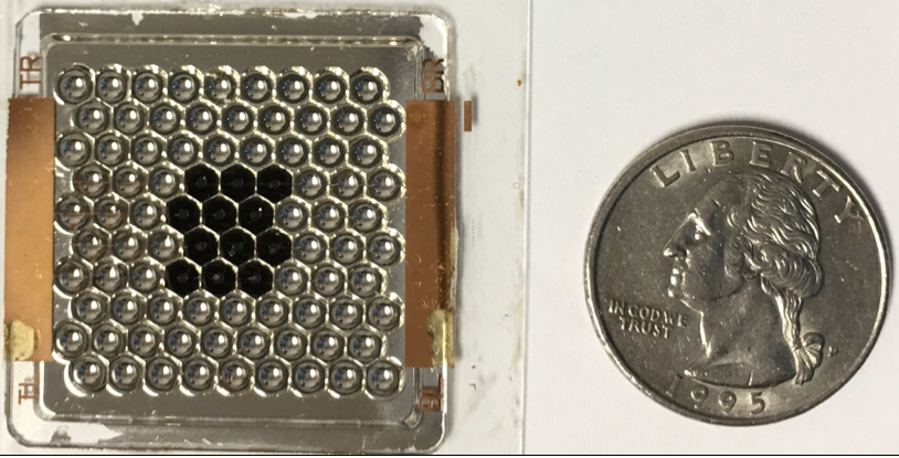 The first prototype, comprising 90 miniaturized solar concentrators, with the first 12 solar cells installed. An American quarter provides the scale. Image courtesy of BGU
