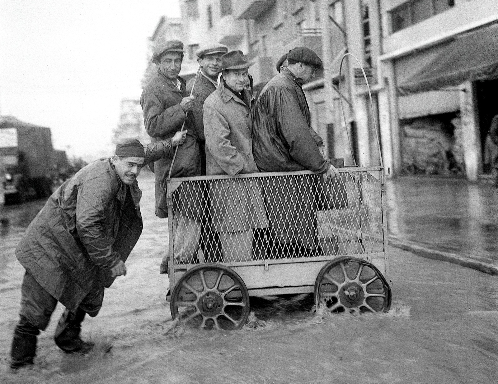 December 1949: A pushcart deliveryman carries passengers over a washed-out Salameh Street in Tel Aviv. Credit: GPO