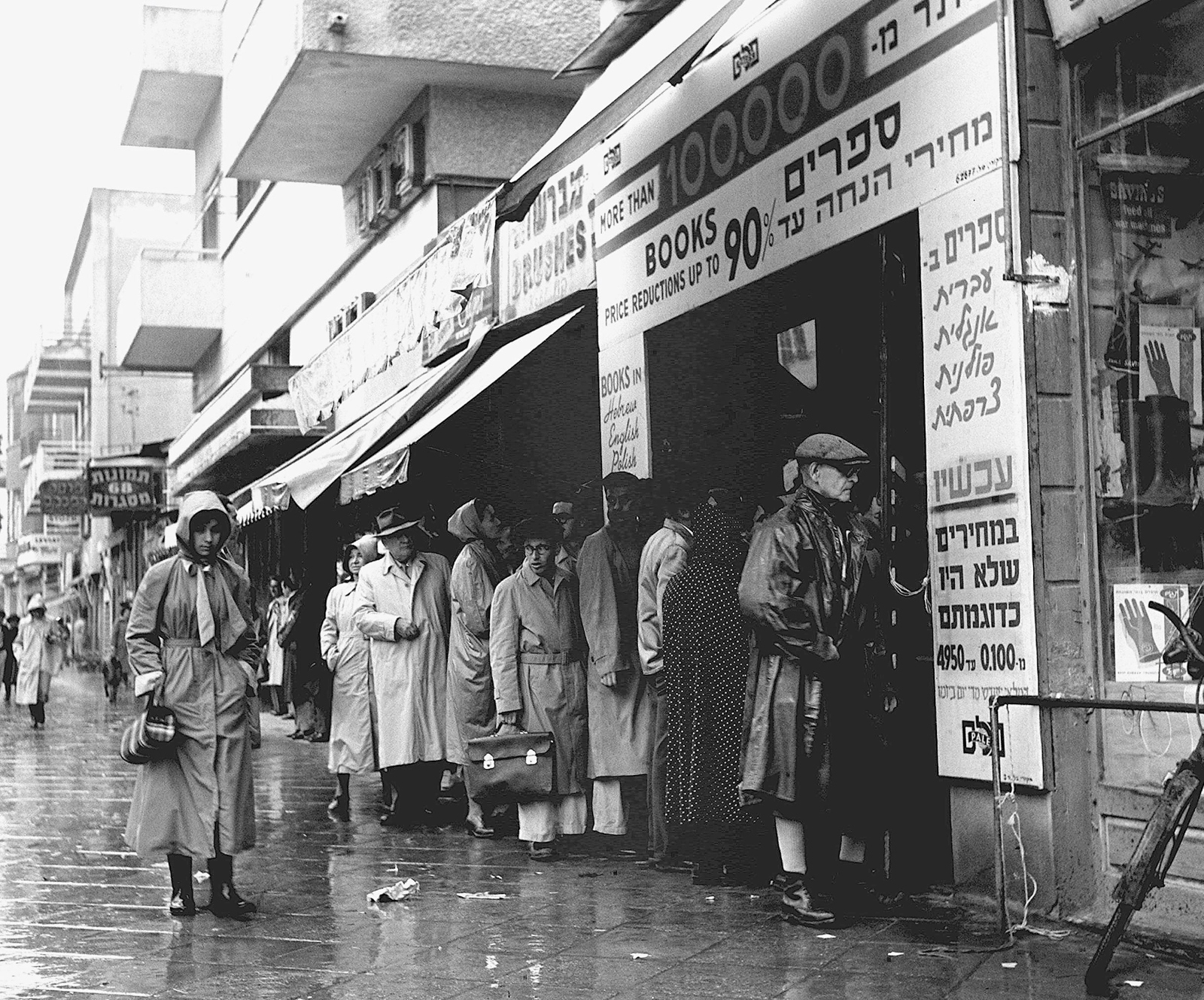 Book lovers line up for bargains on rainy Allenby Street in 1955. Credit: GPO