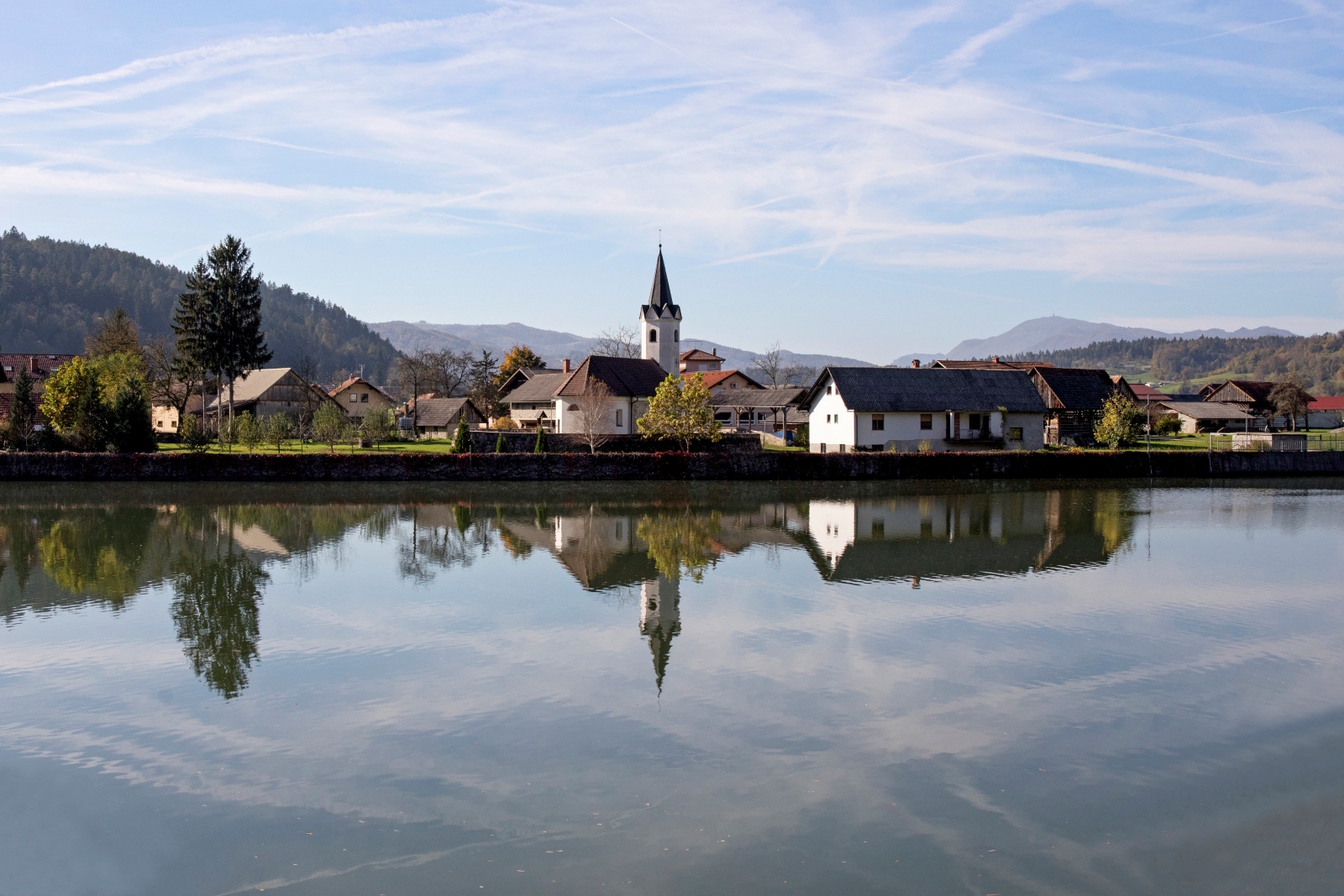 A church and houses in Kompolje, Slovenia, reflect into the waters of the Sava River. Ilan Rogers took this tranquil shot from a moving train.