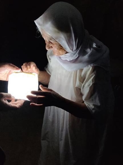A woman in northern Iraq trying a solar lantern brought by SmartAID. Photo: courtesy