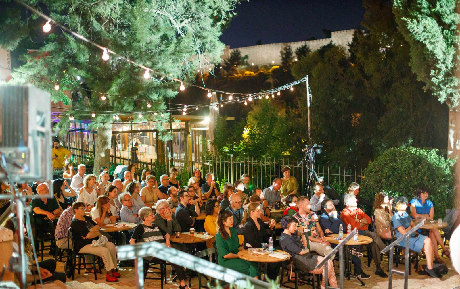 The walls of the Old City peek behind an event at a previous edition of the Jerusalem Writers Festival. Photo by Eliyahu Yannai