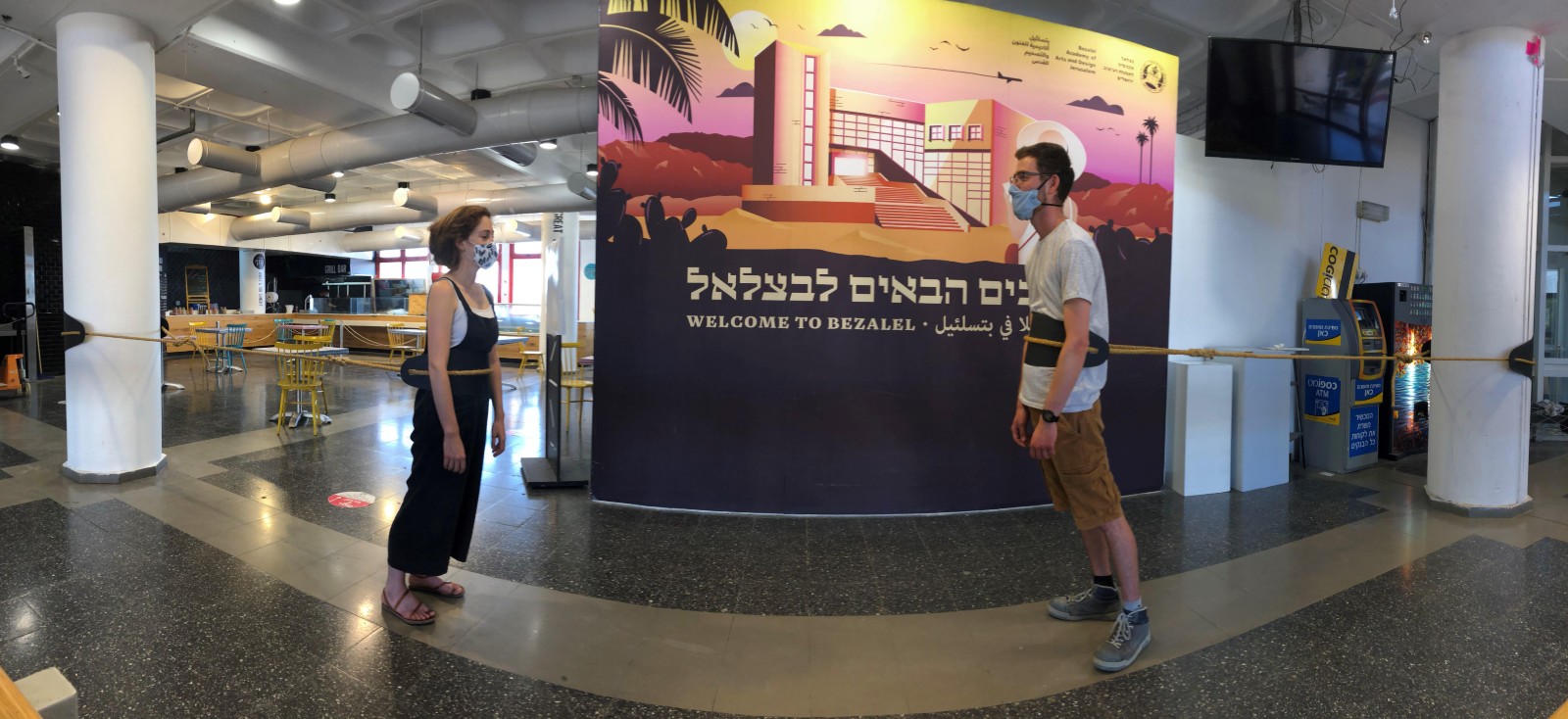 Bezalel students Nir Neria and Arnon Rosenzweig demonstrate a social-distancing contraption they invented in their Structure-Function-Form class. Photo courtesy of Safi Hefetz