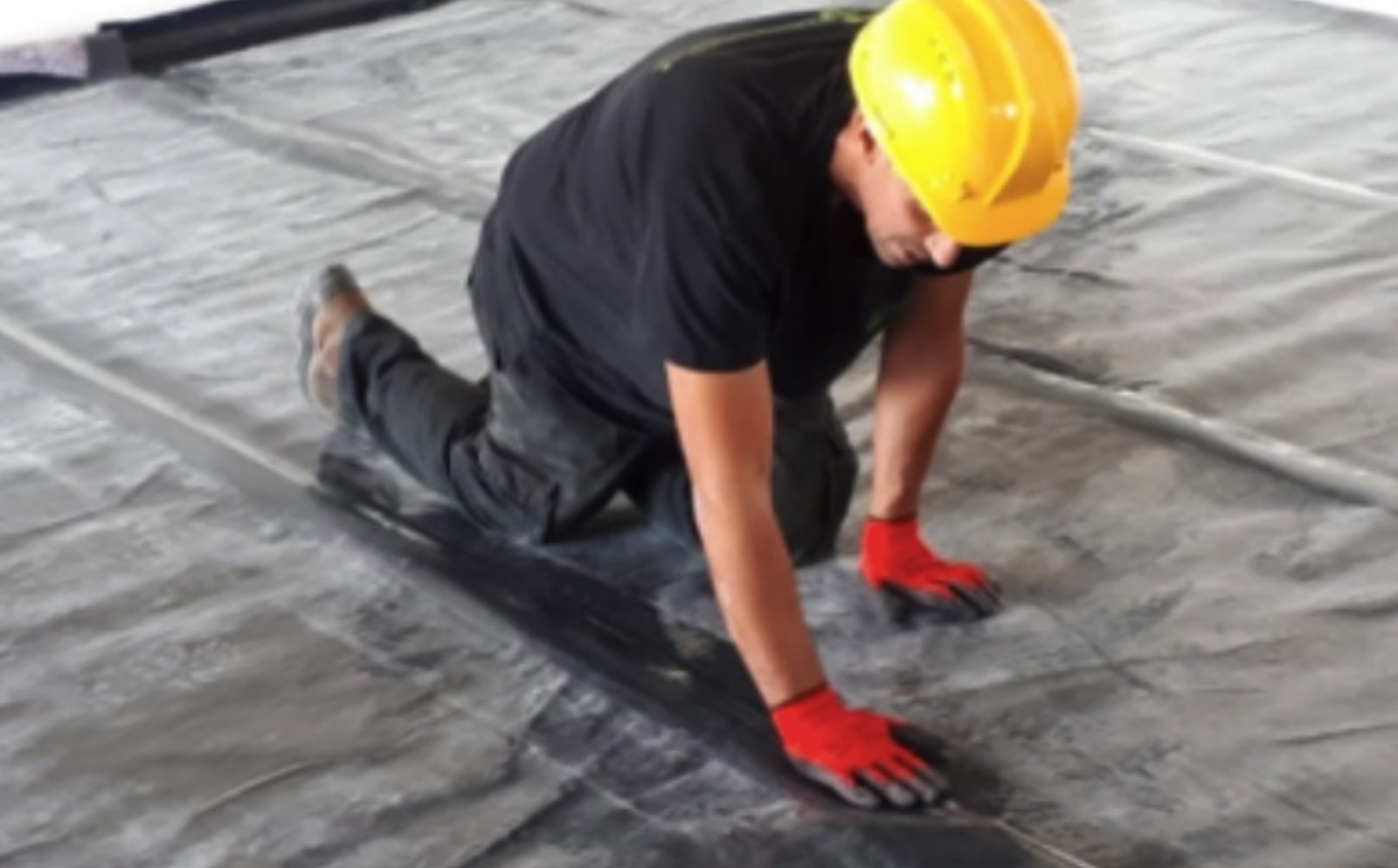 A construction worker using plastic sheeting. Photo courtesy of Alkemy