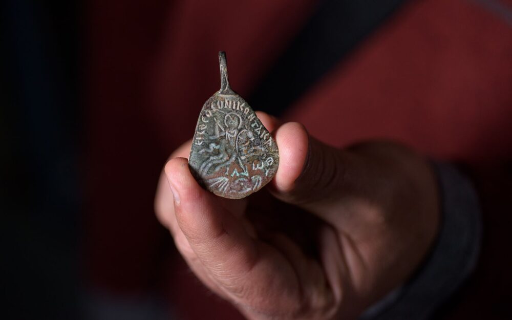 The obverse side of the pendant shows a galloping rider overcoming a demon and the Greek letters for the Jewish Divine Name. Photo by Dafna Gazit/Israel Antiquities Authority