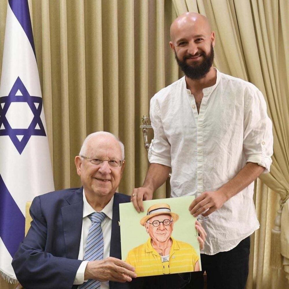 Amit Shimoni presenting President Reuven Rivlin with the caricature he made for the label of Malka Brewery’s Ruvi Beer. Photo by Mark Neyman/GPO