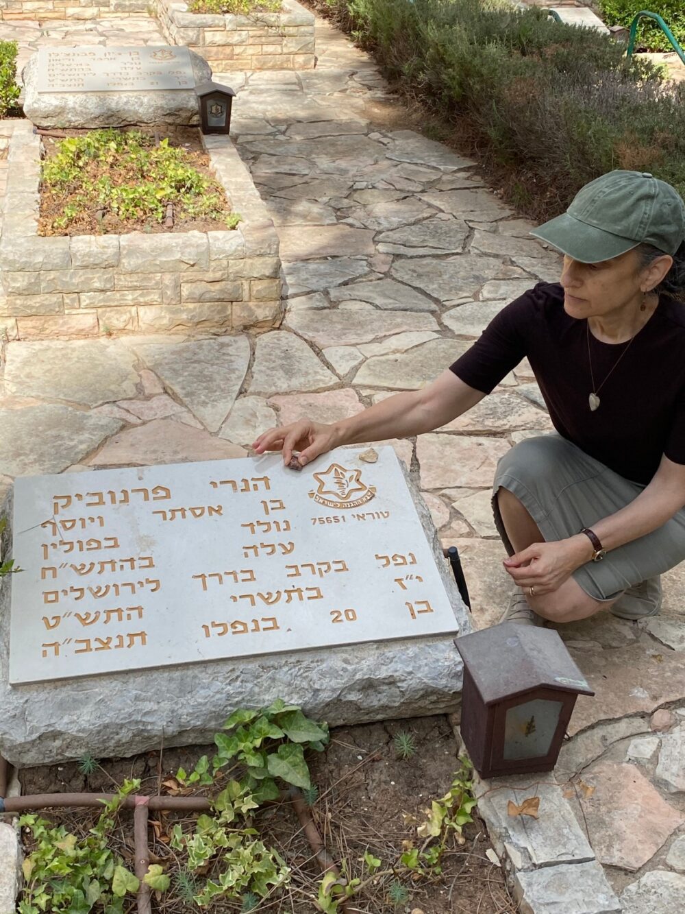 Abigail Leichman placing a pebble on the tombstone of Henri Fernebock. Photo by Steve Leichman