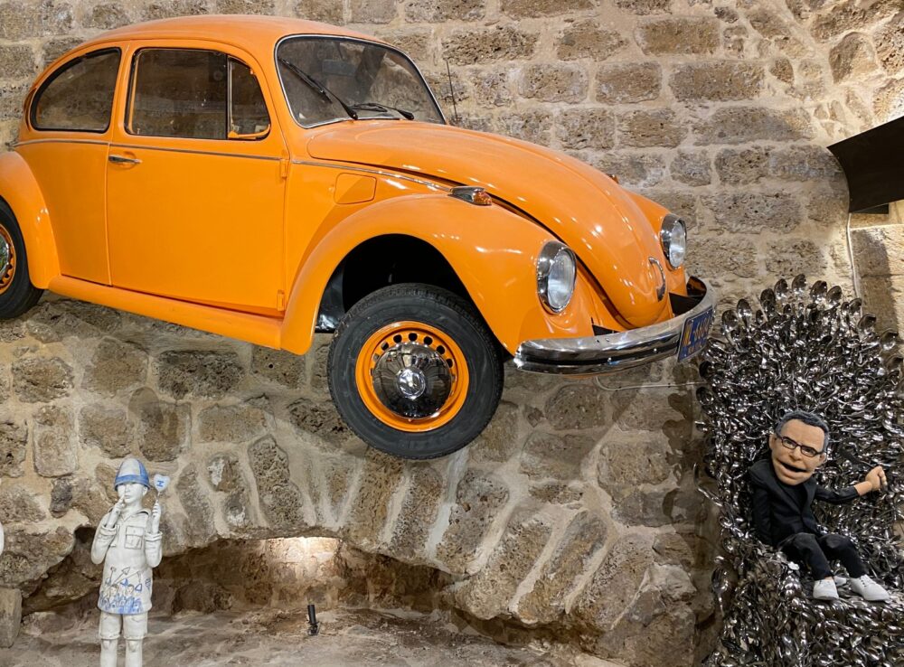 At right is a spoon chair made for Uri Geller by Kellogg’s, with a puppet gifted to him by Noa Kirel. At left is part of Geller’s first car, a Volkswagen Beetle. Photo by Abigail K. Leichman