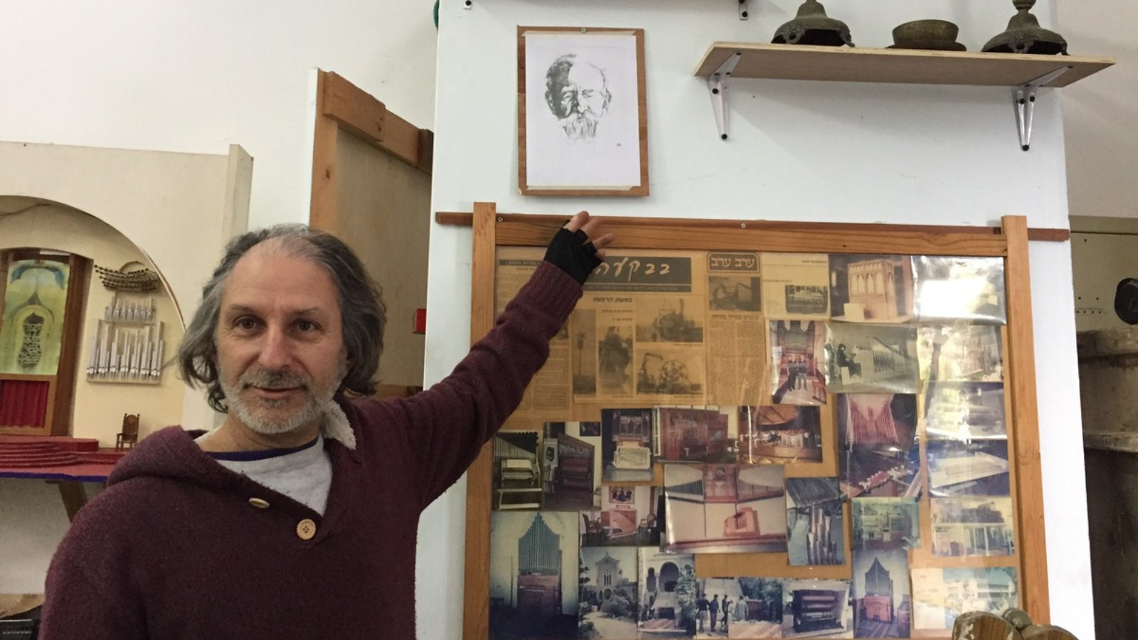 Uri Shani points to a drawing of his great-great-grandfather, a chief cantor. Above are heirlooms from his family's Judaica collection.